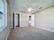 Bedroom featuring carpeted floors, a ceiling fan, a window, and open closet with a view to another room at 1034 Shadowbrook N Dr, Lakeland, FL 33813