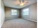 Bedroom featuring carpeted floors, ceiling fan, and two windows overlooking the neighborhood at 1034 Shadowbrook N Dr, Lakeland, FL 33813