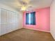 Bedroom features carpeted floors, a ceiling fan, and a closet with louvered doors at 1034 Shadowbrook N Dr, Lakeland, FL 33813