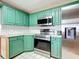 Updated kitchen features green cabinets, stainless steel appliances, and subway tile backsplash at 1034 Shadowbrook N Dr, Lakeland, FL 33813