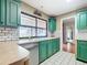 A modern eat-in kitchen features subway tile backsplash, green cabinets, and tile floor at 1034 Shadowbrook N Dr, Lakeland, FL 33813