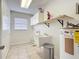 Laundry room features a utility sink, shelving, and a hot water heater with tiled floors at 1034 Shadowbrook N Dr, Lakeland, FL 33813
