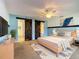 Bright bedroom with decorative barn doors leading to bath and closet; TV and ceiling fan included at 1034 Shadowbrook N Dr, Lakeland, FL 33813