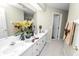 Bright bathroom featuring double sinks, white cabinets, and a large mirror at 1117 Stonebrooke Ln # 58, Lakeland, FL 33803