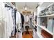 Walk-in closet with custom shelving and chandelier lighting at 1117 Stonebrooke Ln # 58, Lakeland, FL 33803