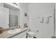 Well-lit bathroom featuring a single sink vanity, toilet, and a shower with a decorative curtain at 1125 Mattie Pointe Blvd, Auburndale, FL 33823
