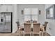 Well-lit dining area with elegant table, decor, and stainless refrigerator at 1125 Mattie Pointe Blvd, Auburndale, FL 33823