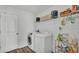 Laundry room with wood look floors, a washer, a dryer and storage shelves at 1125 Mattie Pointe Blvd, Auburndale, FL 33823