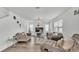 Comfortable living room featuring stylish gray sofas, a modern chandelier, and bright natural light at 1125 Mattie Pointe Blvd, Auburndale, FL 33823