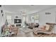 Comfortable living room featuring stylish gray sofas, a modern chandelier, and bright natural light at 1125 Mattie Pointe Blvd, Auburndale, FL 33823
