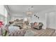 Bright living room flows into the kitchen, showcasing gray sofas, a modern chandelier, and barstool seating at 1125 Mattie Pointe Blvd, Auburndale, FL 33823