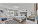 Bright main bedroom featuring a large bed, stylish decor, and ample natural light from the windows at 1125 Mattie Pointe Blvd, Auburndale, FL 33823