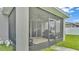 View of the screened-in patio from the backyard, showcasing a cozy outdoor living space at 1125 Mattie Pointe Blvd, Auburndale, FL 33823