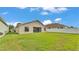 View of the backyard featuring green lawn space with a white fence, and rear exterior of the home at 1129 Bowline St, Winter Haven, FL 33880
