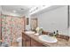 Bathroom featuring double sinks, decorative mirror, and a floral shower curtain at 1129 Bowline St, Winter Haven, FL 33880