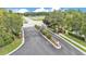 Community entrance with an ornate gate, mature trees, landscaping, and well-maintained grounds at 1129 Bowline St, Winter Haven, FL 33880