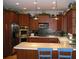Kitchen with custom cabinets, stainless appliances, mosaic backsplash, and bar seating at 12740 Amber Ave, Clermont, FL 34711