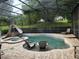 Enclosed pool area featuring a waterslide, hot tub, stone accents, and lounge chairs at 12740 Amber Ave, Clermont, FL 34711