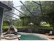 View of an enclosed pool area featuring a slide, hot tub, and landscaping at 12740 Amber Ave, Clermont, FL 34711