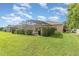 A spacious backyard featuring a screened lanai, lush lawn, and mature landscaping create a private oasis at 13852 Eylewood Dr, Winter Garden, FL 34787