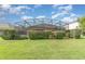 Backyard featuring a well maintained lawn, hedges, and a screened in pool area at 13852 Eylewood Dr, Winter Garden, FL 34787