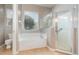 Bathroom offers a glass-enclosed shower, soaking tub, and a large window for natural light at 13852 Eylewood Dr, Winter Garden, FL 34787