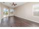 Sunlit bedroom with hardwood floors, ceiling fan, and sliding glass door to the pool area at 13852 Eylewood Dr, Winter Garden, FL 34787