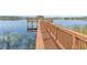 Wooden dock extends over the tranquil lake, an ideal spot for fishing or enjoying nature at 13852 Eylewood Dr, Winter Garden, FL 34787