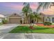 Charming single-story home with a well-maintained lawn, tropical palm trees and a two-car garage at 13852 Eylewood Dr, Winter Garden, FL 34787