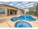 Screened in pool area with a unique pool and spa design and covered patio at 13852 Eylewood Dr, Winter Garden, FL 34787