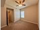 Comfortable bedroom featuring neutral walls, a ceiling fan, carpet flooring, closet, and a sunny window at 14 Morton Rd, Winter Haven, FL 33881