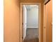 Hallway doorway view leading into bedroom, featuring neutral walls, carpet flooring, and ceiling fan at 14 Morton Rd, Winter Haven, FL 33881
