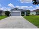 Charming single-story home with a two-car garage, lush landscaping, and a well-maintained front yard at 14 Morton Rd, Winter Haven, FL 33881