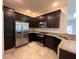 Modern kitchen featuring dark cabinets, stainless steel appliances, granite countertops, and tile floors at 14 Morton Rd, Winter Haven, FL 33881