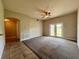 Inviting living room with neutral walls, plush carpet, ceiling fan, and sliding glass doors to the backyard at 14 Morton Rd, Winter Haven, FL 33881
