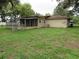 Exterior view of home with a spacious backyard and screened-in patio at 1440 Hackl Blvd, Bartow, FL 33830