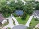 Aerial view of a charming home surrounded by mature trees and lush landscaping at 1589 Royal Forest Ct, Lakeland, FL 33811