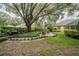 Picturesque backyard with mature trees, a brick patio, and manicured landscaping at 1589 Royal Forest Ct, Lakeland, FL 33811
