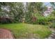 Lush backyard adorned with vibrant flowering bushes and mature trees, offering a private retreat at 1589 Royal Forest Ct, Lakeland, FL 33811