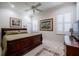 This bedroom features a dark wood bed frame, neutral walls, plantation shutters, and two framed prints at 1589 Royal Forest Ct, Lakeland, FL 33811