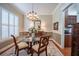 Dining room with a glass table, elegant chandelier, and lots of natural light at 1589 Royal Forest Ct, Lakeland, FL 33811