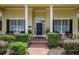 Inviting front door with black shutters, brick walkway, and manicured greenery at 1589 Royal Forest Ct, Lakeland, FL 33811