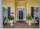 Inviting front entrance with a black door, classic brick walkway, and decorative potted plants enhancing curb appeal at 1589 Royal Forest Ct, Lakeland, FL 33811