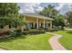 Charming single-story home with a manicured lawn, brick walkway, and stately white columns at 1589 Royal Forest Ct, Lakeland, FL 33811