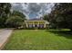 Inviting single-story home featuring a spacious lawn, symmetrical landscaping, and classic columns at 1589 Royal Forest Ct, Lakeland, FL 33811