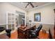 A home office with hardwood floors, a dark wood desk, French doors, and neutral wall color at 1589 Royal Forest Ct, Lakeland, FL 33811