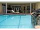 Sparkling pool and patio area with a waterfall feature, outdoor kitchen and dining, and lounge chairs at 1589 Royal Forest Ct, Lakeland, FL 33811