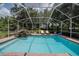 Screened-in pool with lovely stone waterfall feature and poolside lounge chairs at 1589 Royal Forest Ct, Lakeland, FL 33811