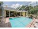 Relaxing screened-in pool with waterfall and poolside seating in a backyard setting at 1589 Royal Forest Ct, Lakeland, FL 33811