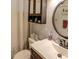 Cozy bathroom featuring a dark-stained vanity, a circular mirror, and a shower with curtain at 1685 Kissengen Ave, Bartow, FL 33830